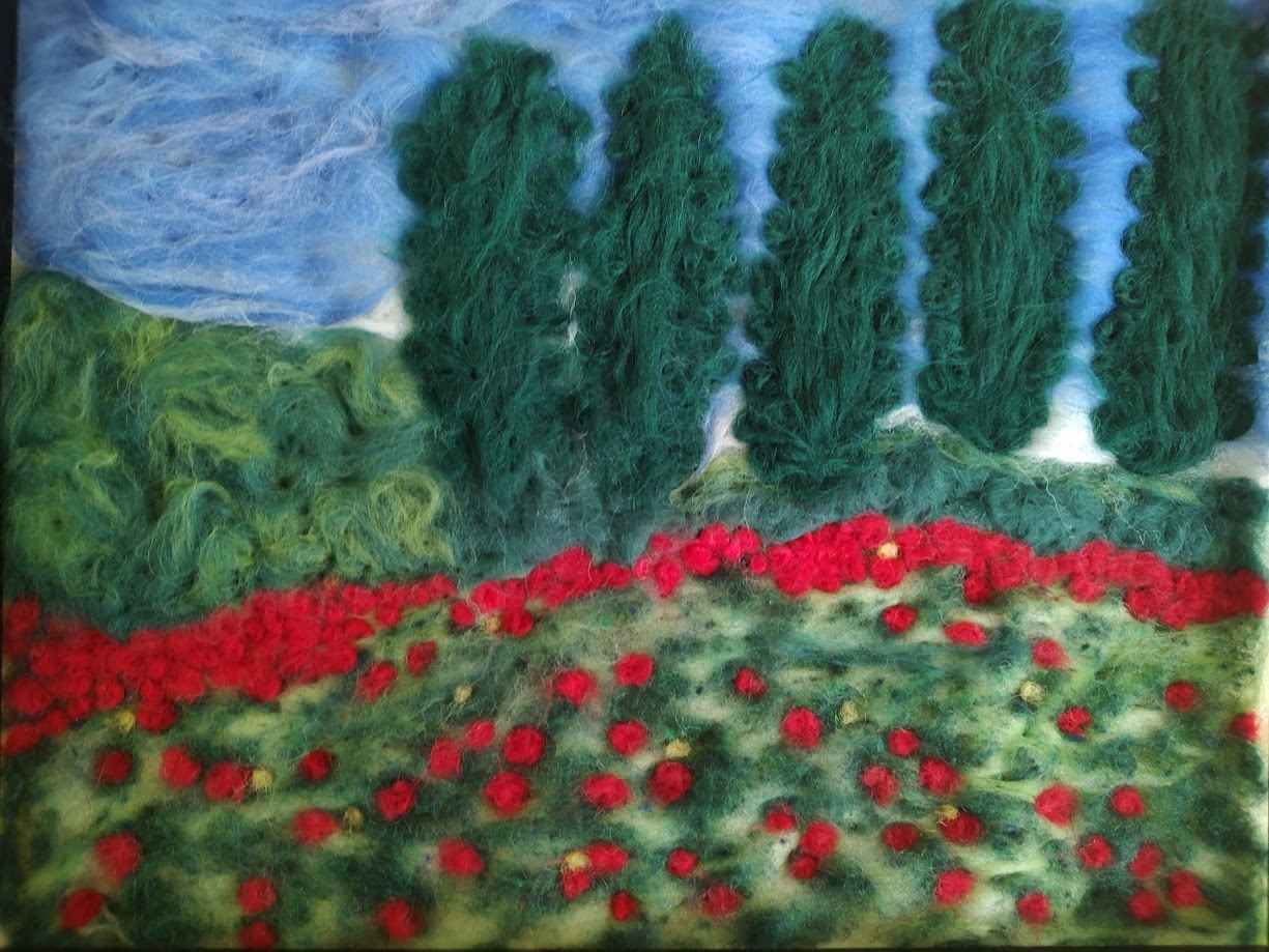 Fiber artwork depicting scene of a field, trees, plants, and a sky.