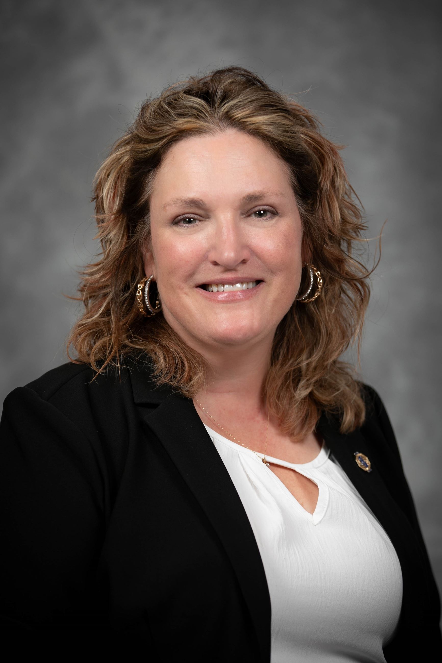 Headshot of a woman wearing a shirt and a blazer.